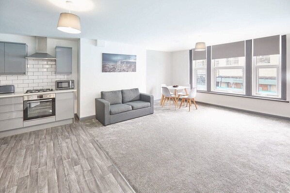 Enjoy a spacious living area with a kitchen, dining space, and large window offering a view of the outside.