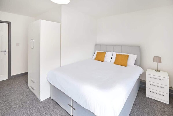 Une chambre à coucher avec un lit, une armoire et une table de chevet.