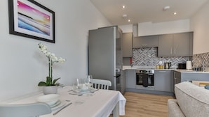 Una cucina moderna con mobili grigi, forno integrato e backsplash a spina di pesce.