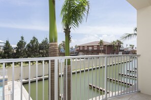 A balcony with a view of a swimming pool and a building in the background.