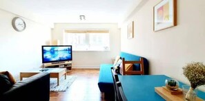 A living room with a television, sofa, and a window. - 2 Bedroom Apt in the Heart of the City Centre, perfect Location (Glasgow)