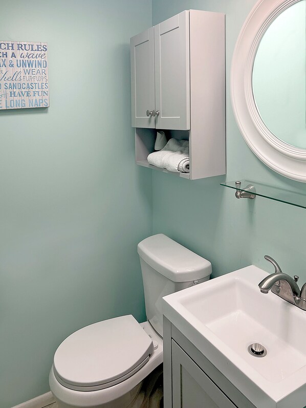 Un baño con inodoro, lavabo y mueble.