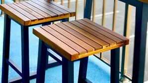 A balcony with a wooden table and two benches.