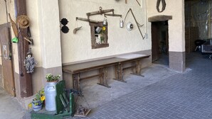 A rustic interior with a wooden bench, a small window with a sunflower, and various hanging items like a basket and a hook. - s Moose Hof (Weisweil)