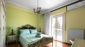 A bedroom with a bed, nightstands, a chandelier, and a view of the outdoors. - Fairytale, Nilie Hospitality MGMT (Thessaloniki)