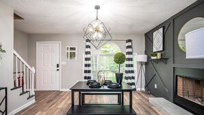 A modern dining area with a black table, white door, and a fireplace. - Renovated townhouse in Norcross (Norcross)