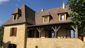 A stone house with a gabled roof, multiple windows, and a covered porch. - Large 3* house in Périgord 10 minutes from Sarlat (Marquay)