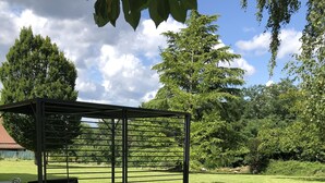 A metal gazebo with a roof and seating area in a grassy outdoor space. - Large 3* house in Périgord 10 minutes from Sarlat (Marquay)