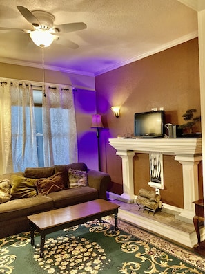 Una sala de estar con sofá, mesa de centro y chimenea.