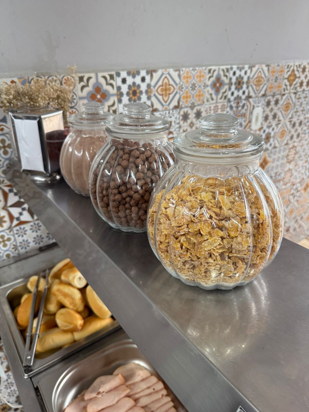 A buffet with various food items including cookies, cereal, and pastries.