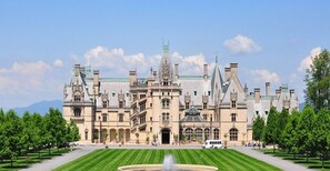 A large, historic building with a symmetrical facade, multiple towers, and a central entrance.