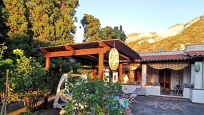 A courtyard with a pergola, seating area, and a decorative stone pattern on the ground. - La Magnolia Casa Vacanze (Sicilia)