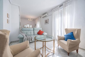 A living room with a sofa, armchairs, a glass coffee table, and a mirror on the wall. - Al-Andalus Stately Home Casa Atalaya Center (Cordoba)