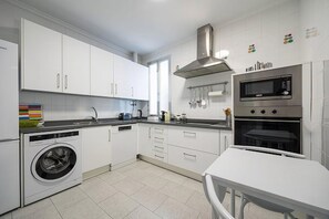 A modern kitchen with white cabinets, a built-in washing machine, a microwave, and an oven. - Stately Home Casa Atalaya Center Córdoba (Cordoba)