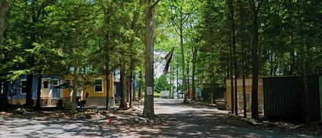 Een camping met campers en stacaravans, omgeven door bomen.