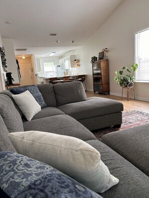 Relax in this stylish living room with a sofa, dining area, and wicker sideboard.