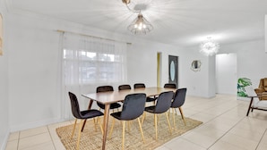 A dining area with a table and chairs, a ceiling light, and a rug. - Private lakefront charming Home in Miami/Pembroke (Pembroke Pines)