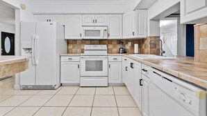 A modern kitchen with white cabinetry, a built-in oven, microwave, and a stainless steel sink. - Private lakefront charming Home in Miami/Pembroke (Pembroke Pines)