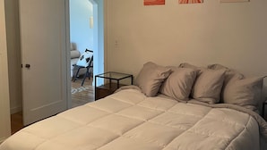 A bedroom with a large bed, a ceiling fan, and wall art. - Oak Street Farm House (Omak)