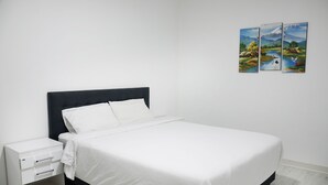 A bedroom with a bed, a nightstand, and three framed pictures on the wall.