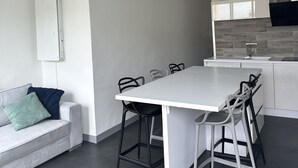Une cuisine moderne avec un plan de travail blanc, des carreaux gris et un four encastré.