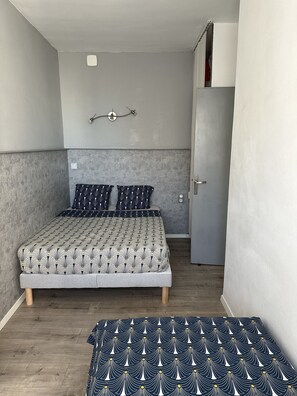 Cozy retreat with a single bed, geometric patterned bedspread, and minimalist design.