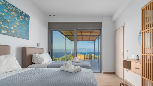 A modern bedroom with two beds, a large window, and a view of the sea. - Messinian Riviera Villas (Petalidi)