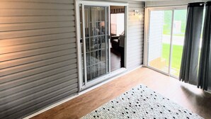 A room with a sliding glass door leading to a patio, a patterned rug, and a ceiling with recessed lighting.