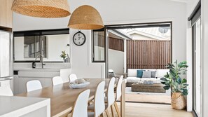 Enjoy meals in the dining area with a wooden table and comfortable white chairs.