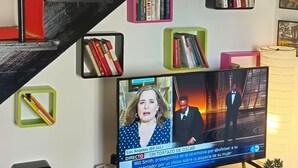 Eine Treppe mit roten Stufen und schwarzen Geländern, umgeben von Bücherregalen mit unterschiedlichen Büchern.