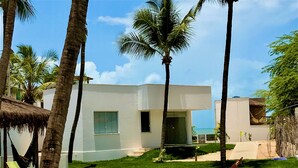 A modern villa with a swimming pool, surrounded by palm trees and a clear sky. - Beach Front Exclusive Villa with Pool (SAO MIGUEL DO GOSTOSO)