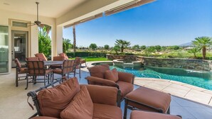A poolside area with outdoor seating and a view of a landscaped garden. - La Quintuta -- our home away from home (La Quinta)
