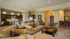 A spacious living room with a large sectional sofa, a coffee table, and a dining area with chairs. - La Quintuta -- our home away from home (La Quinta)