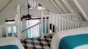 Une chambre avec un sol à carreaux, des murs blancs et un ventilateur de plafond.