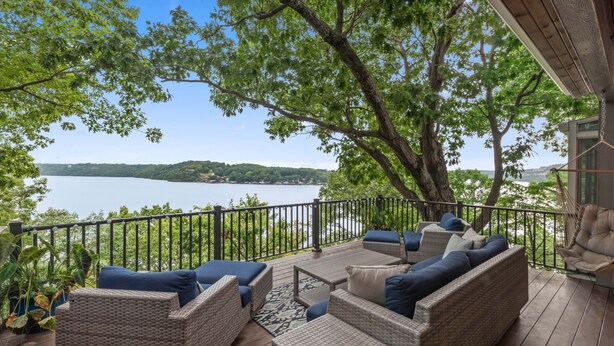 A deck with wicker furniture and a view of a lake. - Lofted Bluff Sunset Lake Views and Private Boat Dock (Osage Beach)