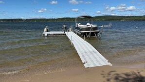 Un muelle de madera se adentra en un lago, con una embarcación amarrada al final.