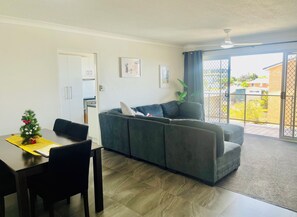 Relax in a comfortable living space with a dining area and seating area, featuring a sofa, plant, and framed pictures.