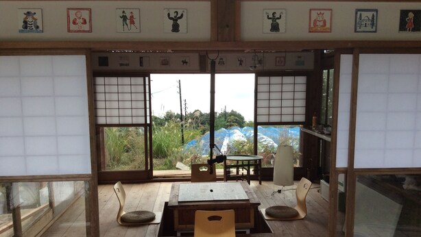 Ein traditioneller japanischer Raum mit Tatami-Böden, einem niedrigen Holztisch und Shoji-Schirmen.
