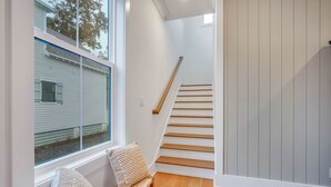 A staircase with wooden steps and a handrail, leading to an upper floor. - Luxurious Living in Old Town Bluffton! Sleeps 6! Prime Location! (Bluffton)