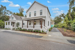 A two-story house with a front porch, a covered entryway, and a small front yard.