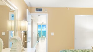 A hotel room with a bed, a dresser, a mirror, and a view of the balcony. - Best View on Marco Island, #909 @ the Apollo (Marco Island)