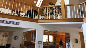 Ein mehrgeschossiges Interieur mit Holzbalken, einer Treppe und einer Küchenzeile.