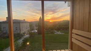 Un pontile di legno con vista su un tramonto su un parco e un edificio.