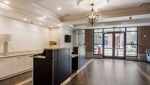 A reception area with a counter, a television, and a large window with a view of the outside. - Charleston 1BR Deluxe Prime King Street property (Charleston)