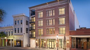 A multi-story building with a brick facade, large windows, and a flat roof. - Charleston 1BR Deluxe Prime King Street property (Charleston)