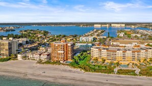 A coastal resort with multiple hotel buildings, a marina, and a beach.