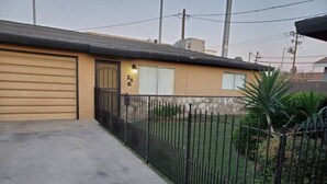A residential house with a garage, a fenced yard, and a small garden. - Bakersfield Safari Retreat (Bakersfield)