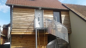 A wooden building with a metal spiral staircase leading to a door. - House (Wintzenheim)