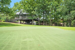 A golf course with a house in the background. - Rustic Log Cabin Near Thunder Ridge w Private Hot Tub & Free Attraction Tickets_Community Amenities! (Ridgedale)