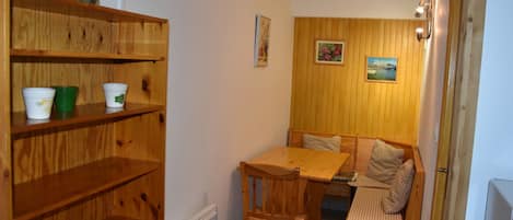 Una habitación acogedora con muebles de madera, una mesa de comedor y bancos.
